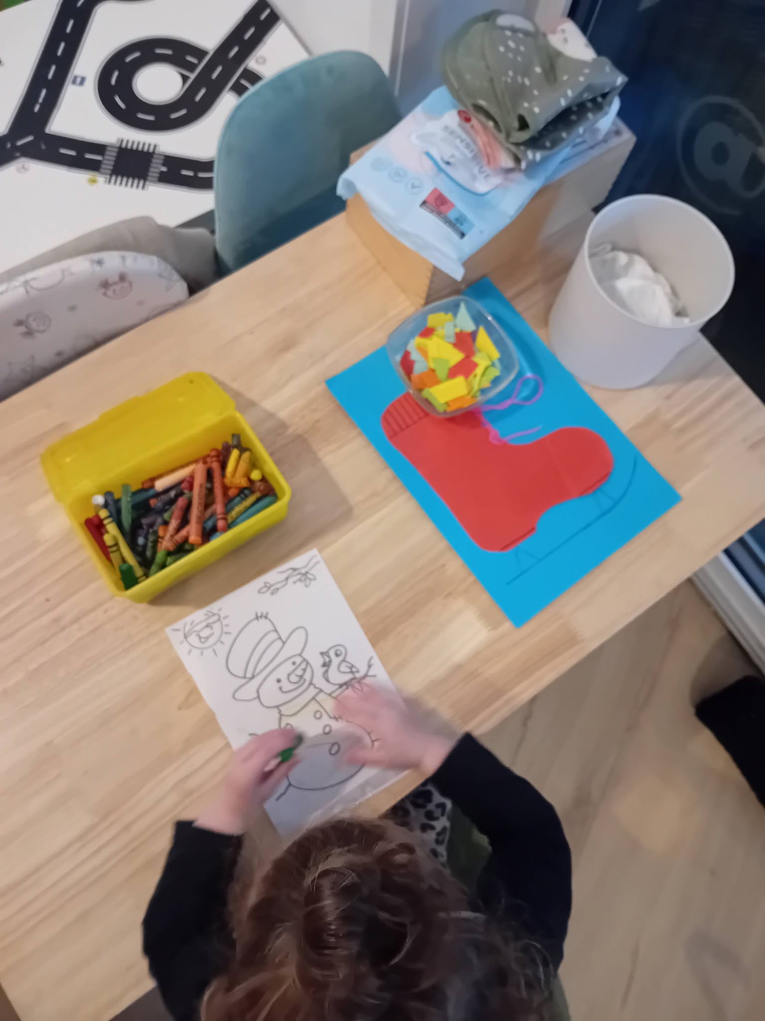 Kind kleurt een sneeuwpop aan de knutseltafel
