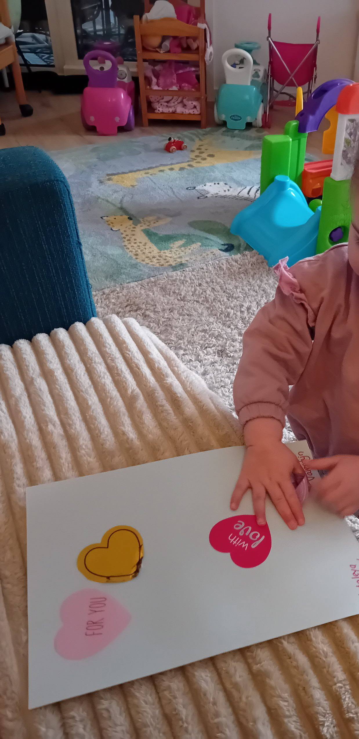 Kind plakt hartjesstickers op een kaartje